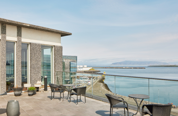 Center Hotels Arnarhvoll 酒店 SKÝ Bar 屋顶露台,尽览法赫萨湾、群山、哈帕音乐厅与雷克雅未克市中心全景。